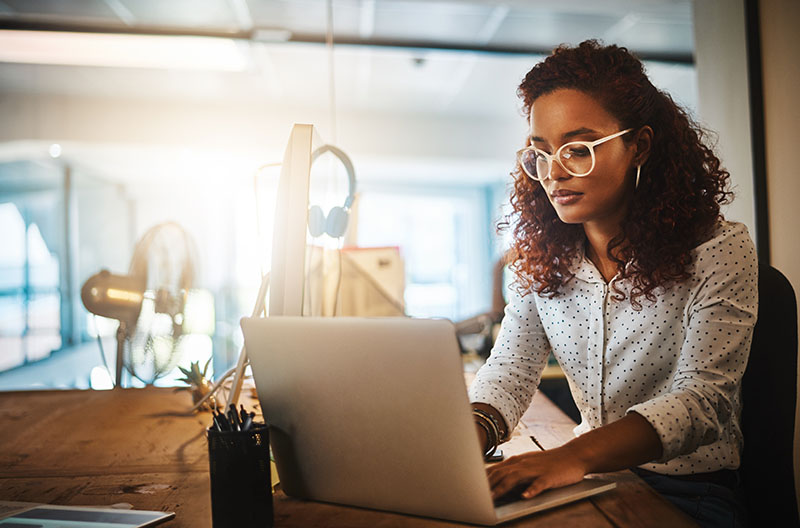 A woman works on her laptop in an office